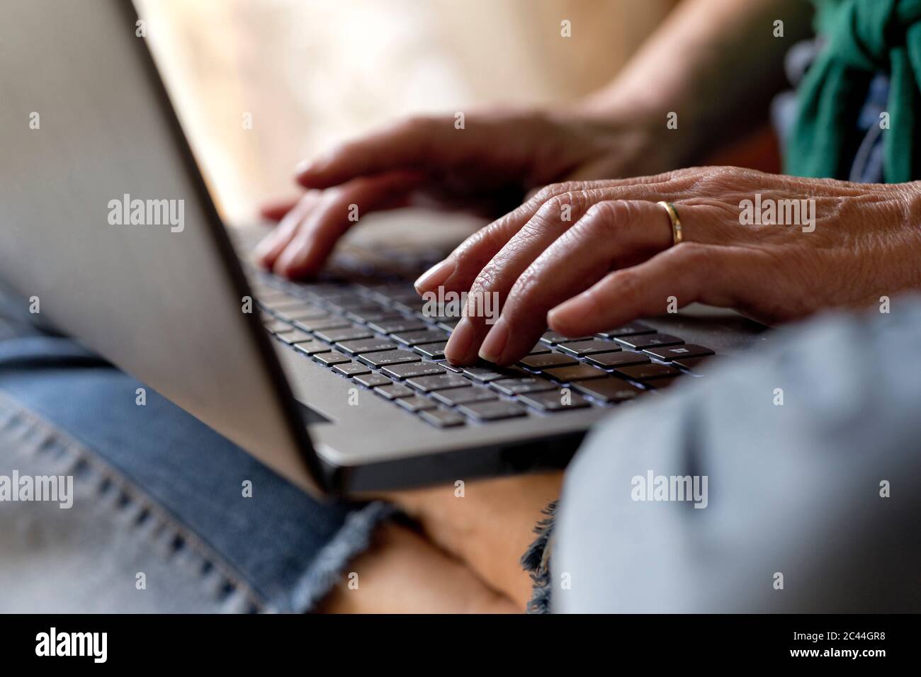 Donna matura che usa il laptop mentre lavora a casa durante il coprifuoco Foto Stock