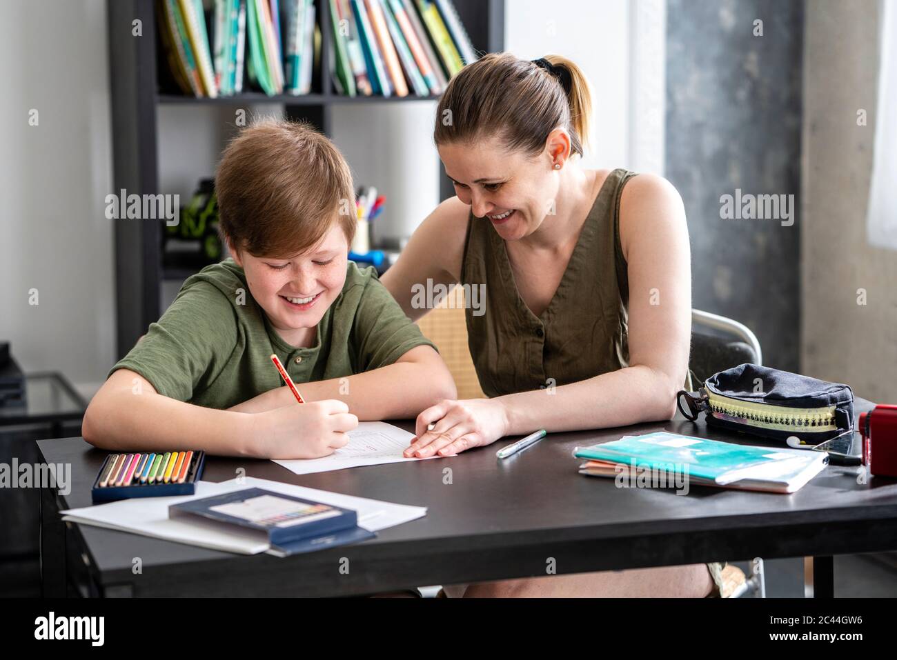 Madre che homeschooling suo figlio a casa Foto Stock