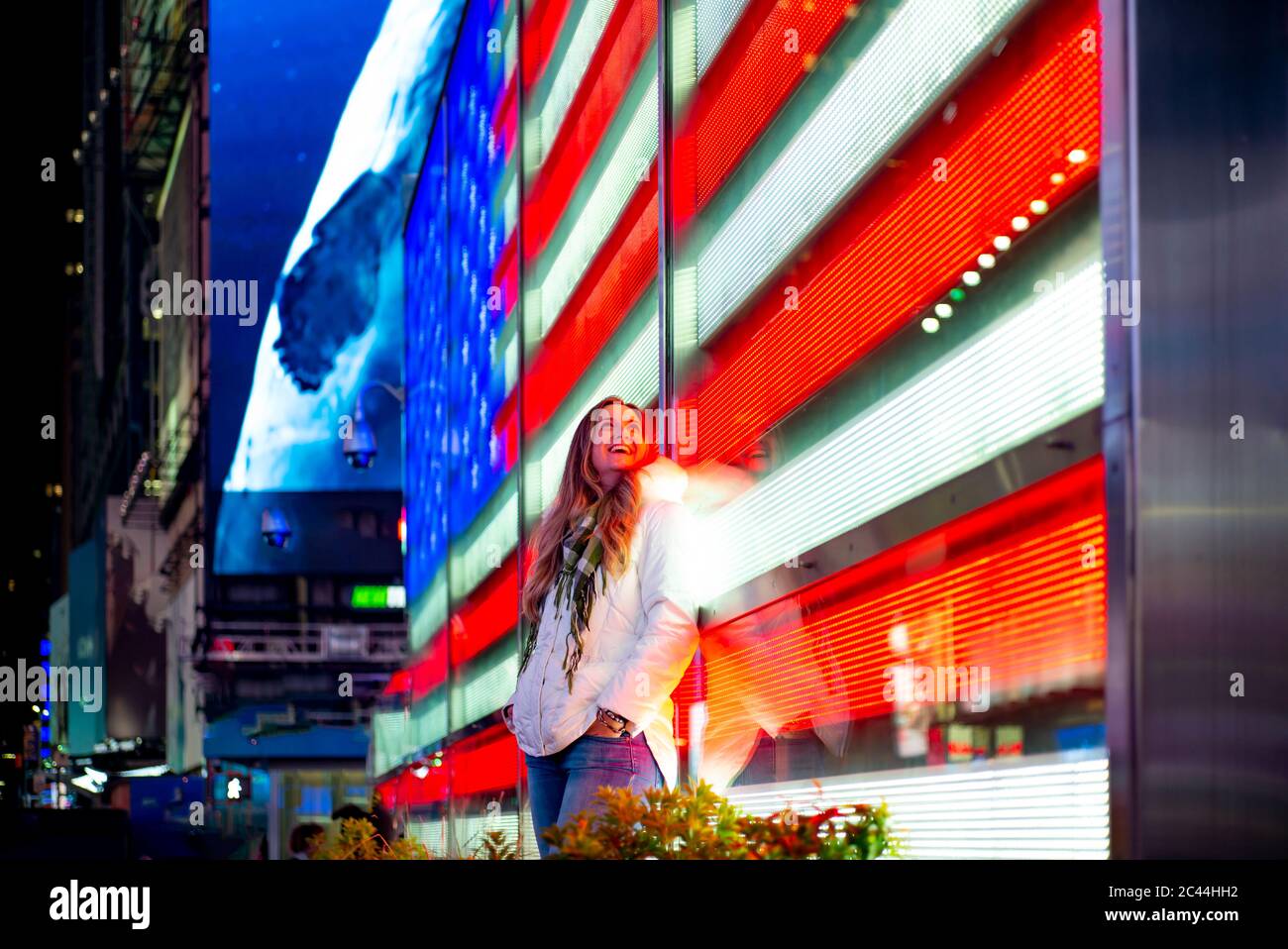 Stati Uniti d'America, New York New York City, Ritratto di giovane donna bella poggiando su Times Square il display a LED di notte Foto Stock