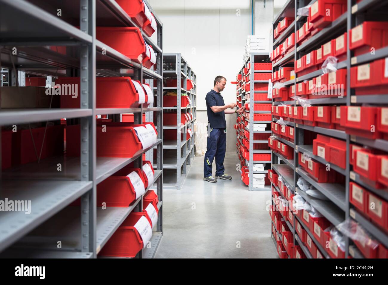 Uomo in magazzino di una fabbrica di scansione merci Foto Stock