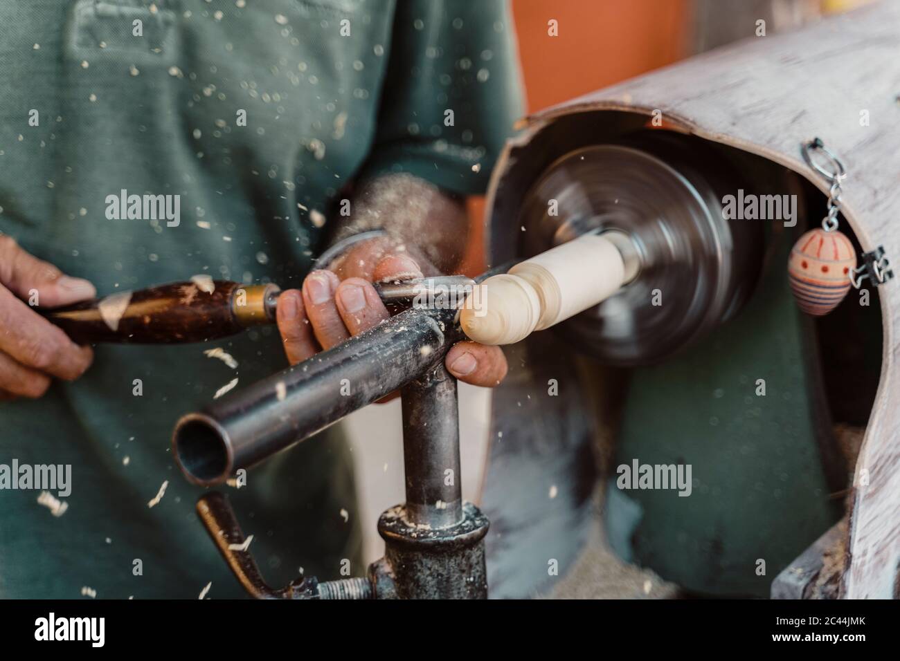 Sezione mediana del falegname maschio holding scalpello durante la sagomatura del legno in officina Foto Stock