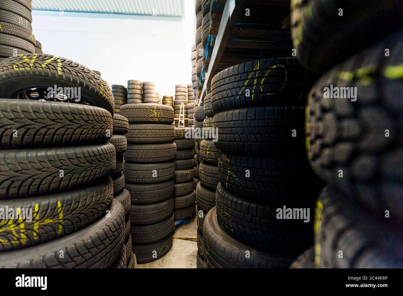 Primo piano dei pacchi di pneumatici in gomma nel punto vendita illuminato Foto Stock