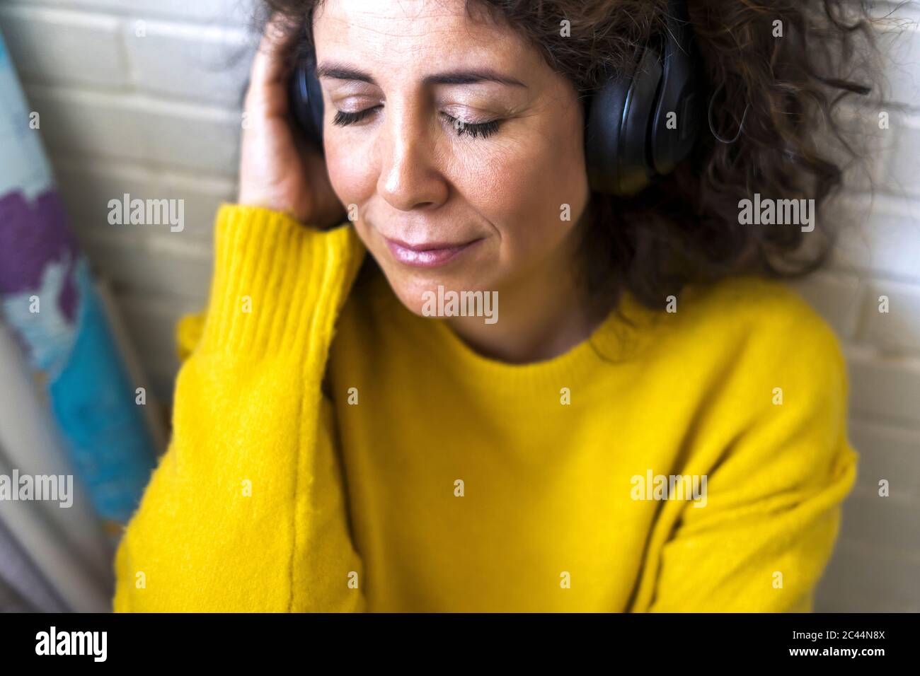 Ritratto di donna con occhi chiusi che ascolta la musica con le cuffie Foto Stock