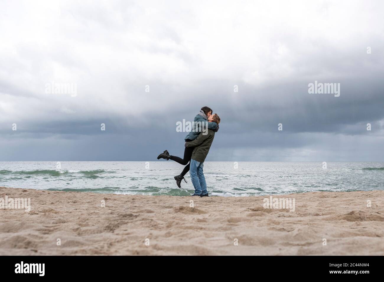 Russia, Kaliningrad Oblast, Zelenogradsk, Coppia adulta che si bacia sulla spiaggia sabbiosa costiera del Mar Baltico Foto Stock