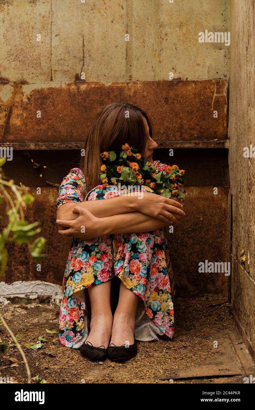 Triste donna sola seduta in contenitore Foto Stock