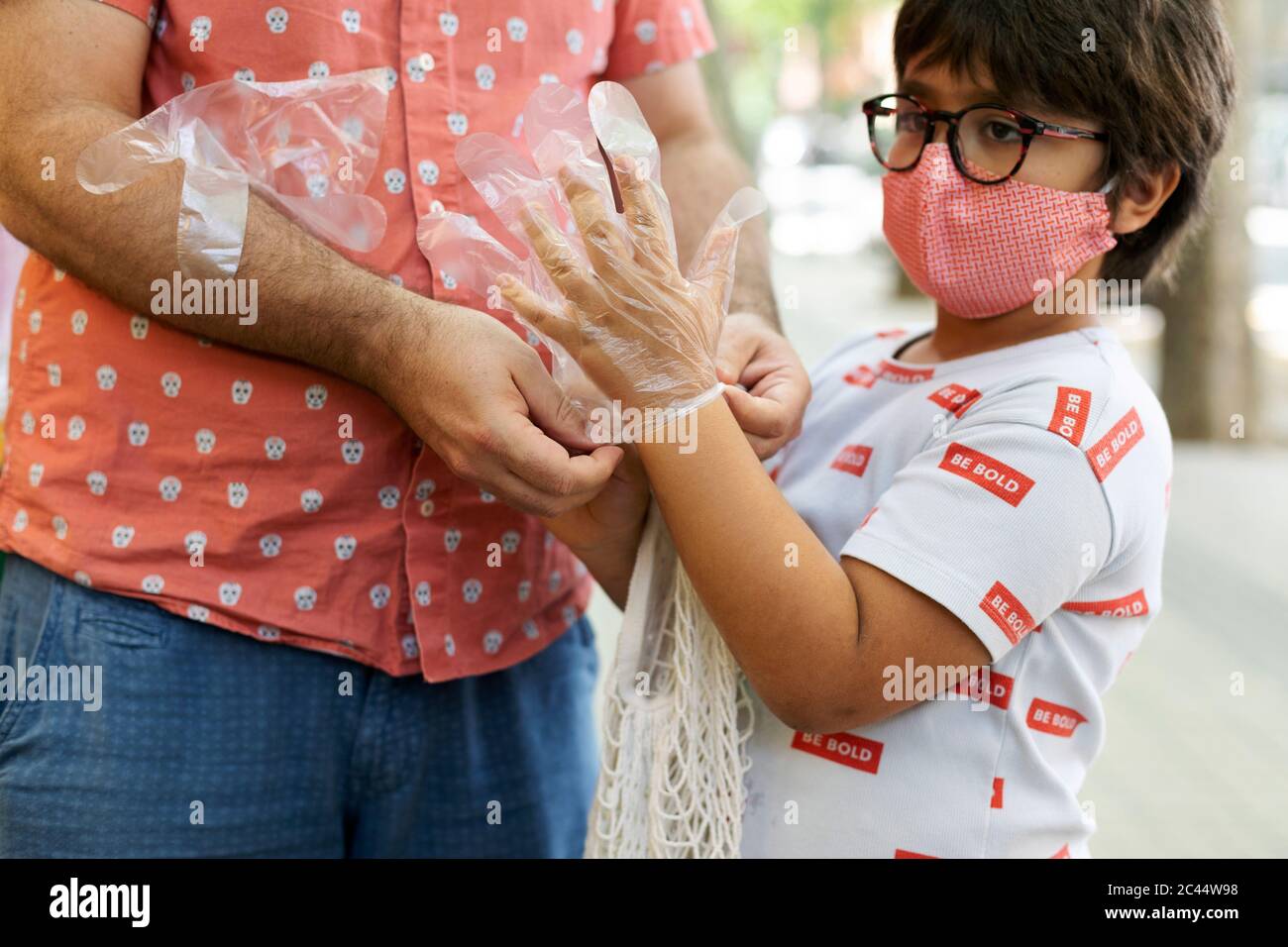 Padre che indossa i guanti di suo figlio prima di fare shopping Foto Stock