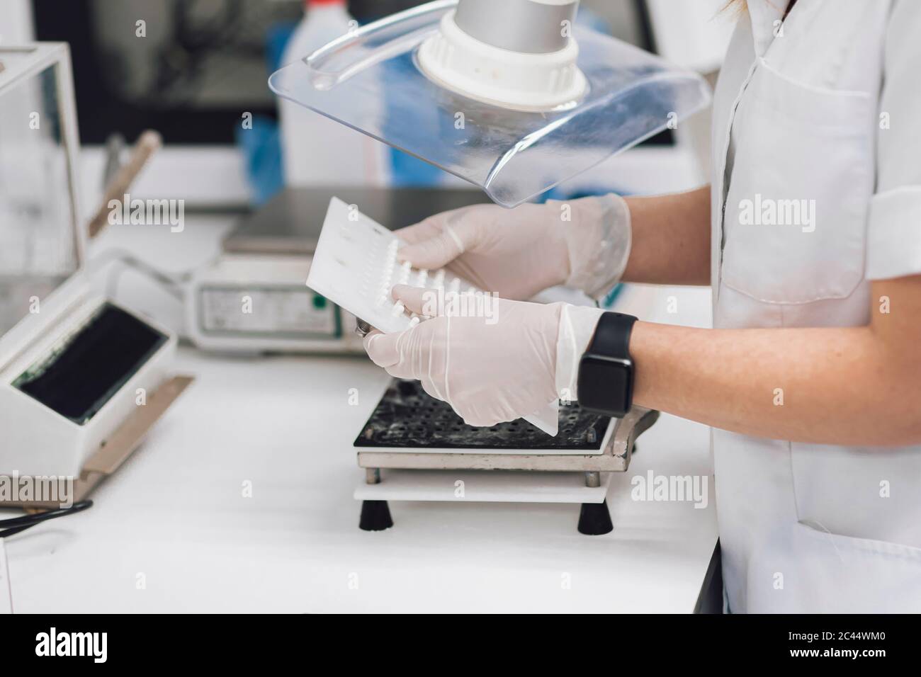 Medico femminile maturo che tiene attrezzature mediche in laboratorio Foto Stock