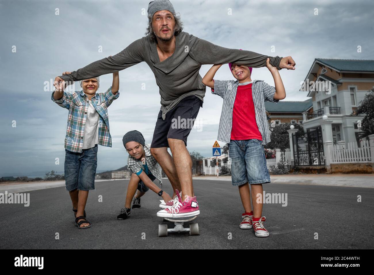 Padre sta imparando a cavalcare lo skateboard Foto Stock