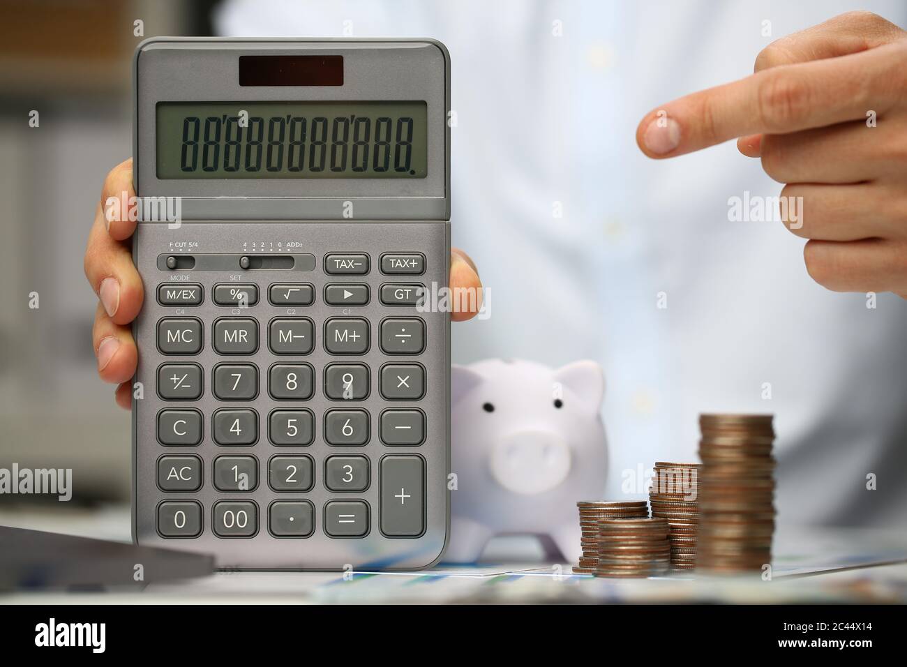Giovane uomo che punta il dito verso la calcolatrice grigia Foto Stock