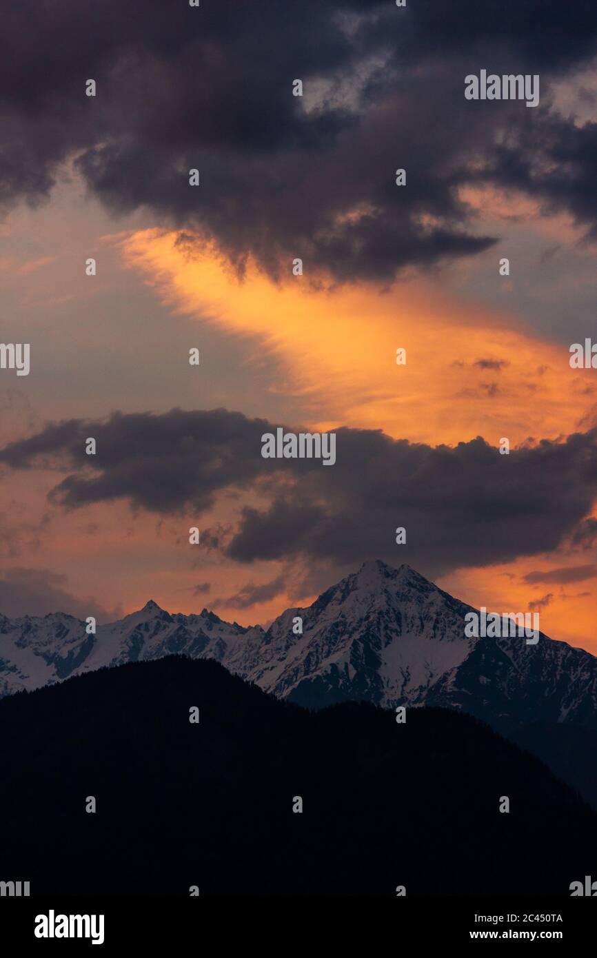 I colori del tramonto riempiono il cielo sopra la montagna Himalaya di Shrikhand Mahadev a Sarahan Foto Stock