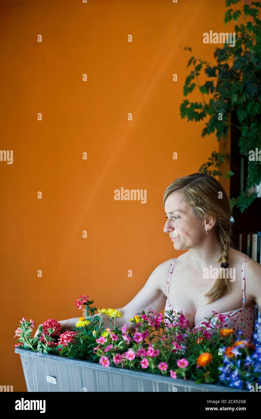 Donna bionda porta una scatola di fiori Foto Stock
