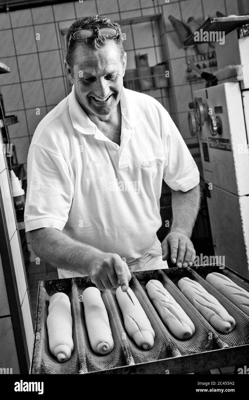 Baker prepara baguette Foto Stock