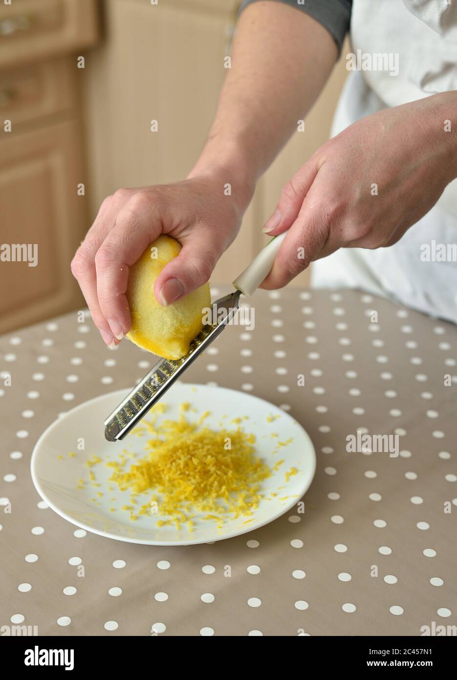 Primo piano di donna che strofina la scorza di limone sul grattugia Foto Stock
