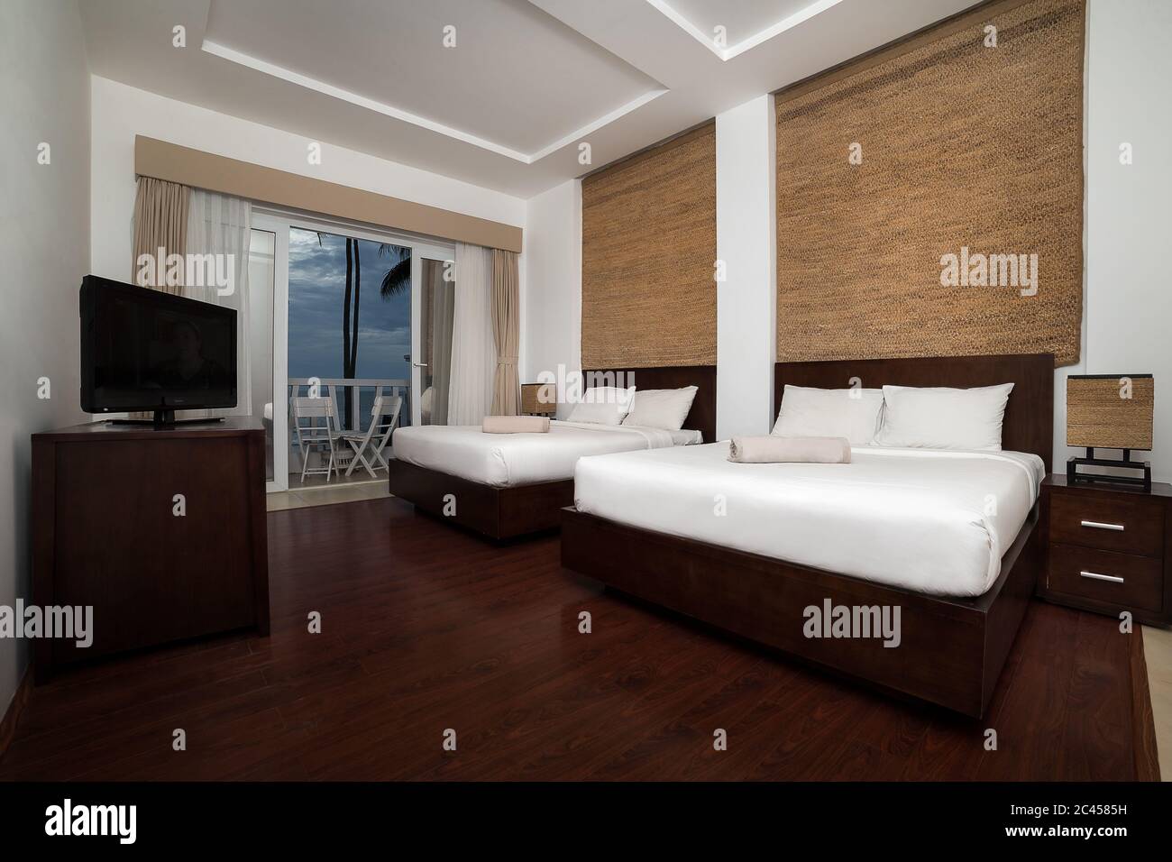 Interno di una moderna camera da letto con pareti bianche e due grandi letti nel centro della camera Foto Stock