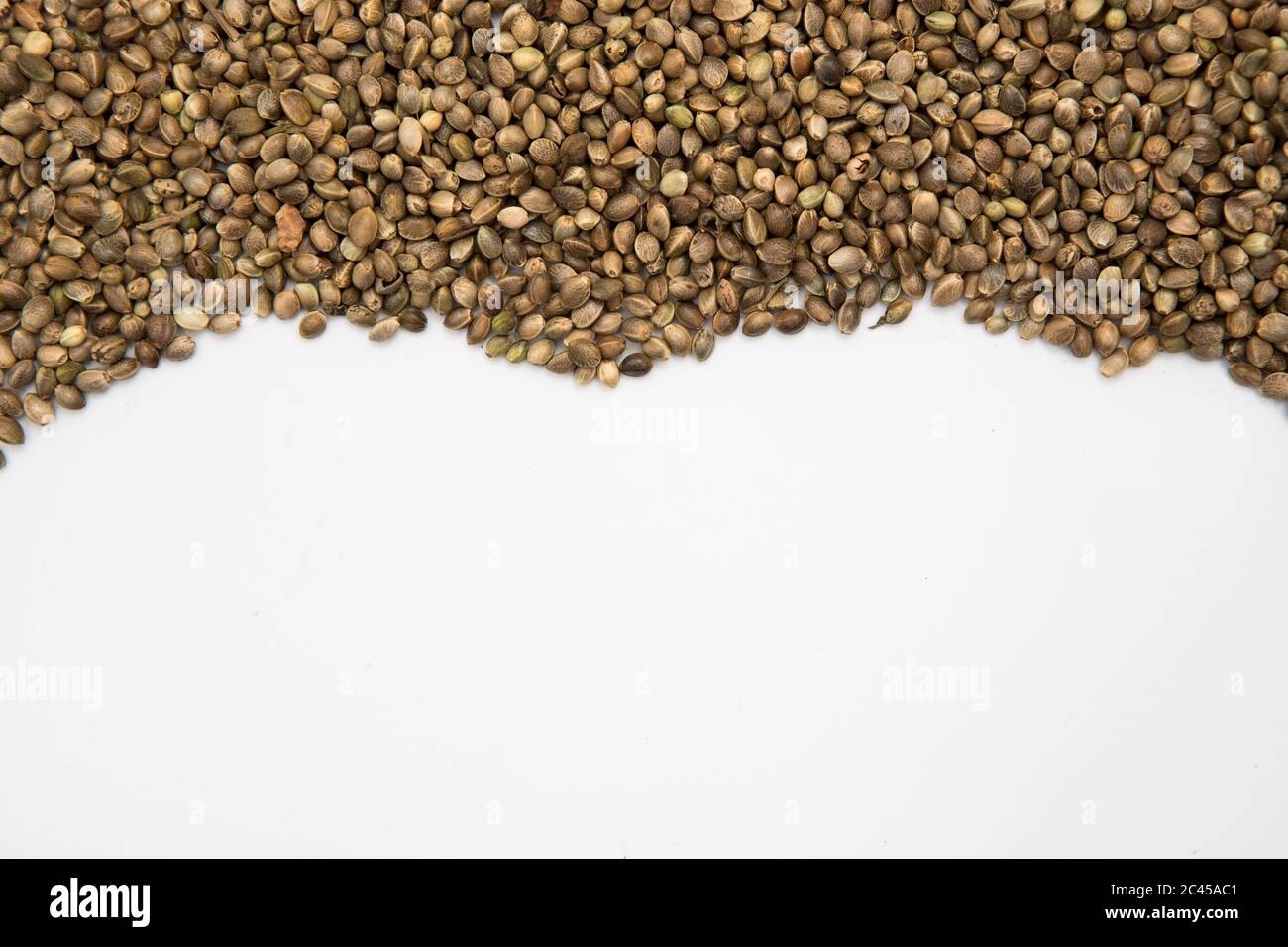 Sfondo semi di canapa con spazio di copia bianco. Texture naturale in macro Foto Stock