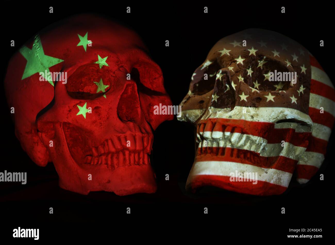 Cina e Stati Uniti si affrontano. Teschi opposti con emblema nazionale o simbolo patriottico bandiera proiettato sopra. Sfondo nero isolato. Tensioni politiche con Foto Stock