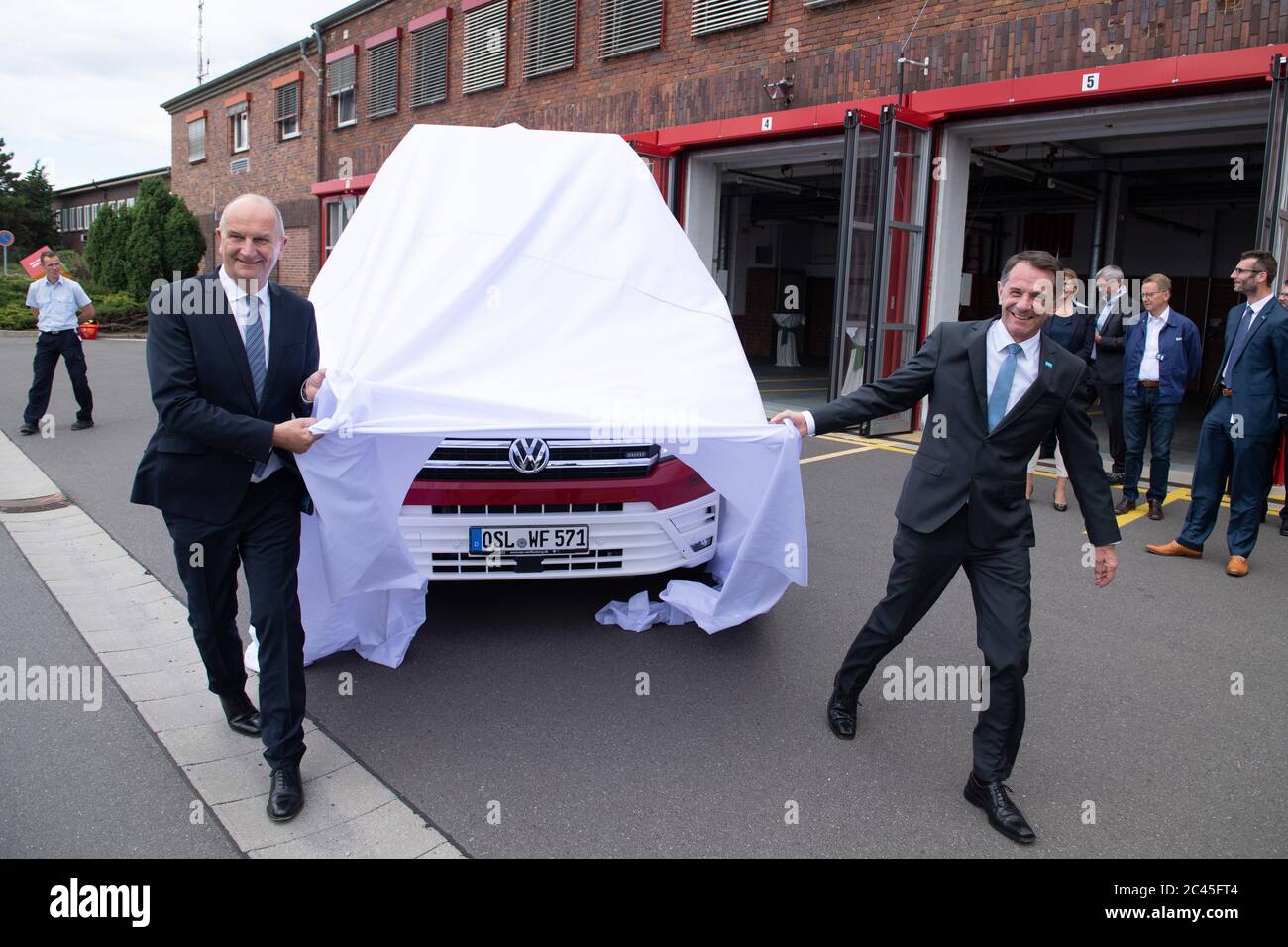 Schwarzheide, Germania. 24 Giugno 2020. Jürgen Fuchs (r), presidente del consiglio di amministrazione di BASF Schwarzheide GmbH, e Dietmar Woidke (SPD), ministro del Brandeburgo, svelano un veicolo di misurazione ambientale del reparto antincendio di fronte alla stazione antincendio della sede di BASF Schwarzheide GmbH. Durante la sua visita, Woidke si è informato sullo stato attuale dei vari progetti di investimento dell'azienda. Credit: dpa/dpa-Zentralbild/dpa/Alamy Live News Foto Stock