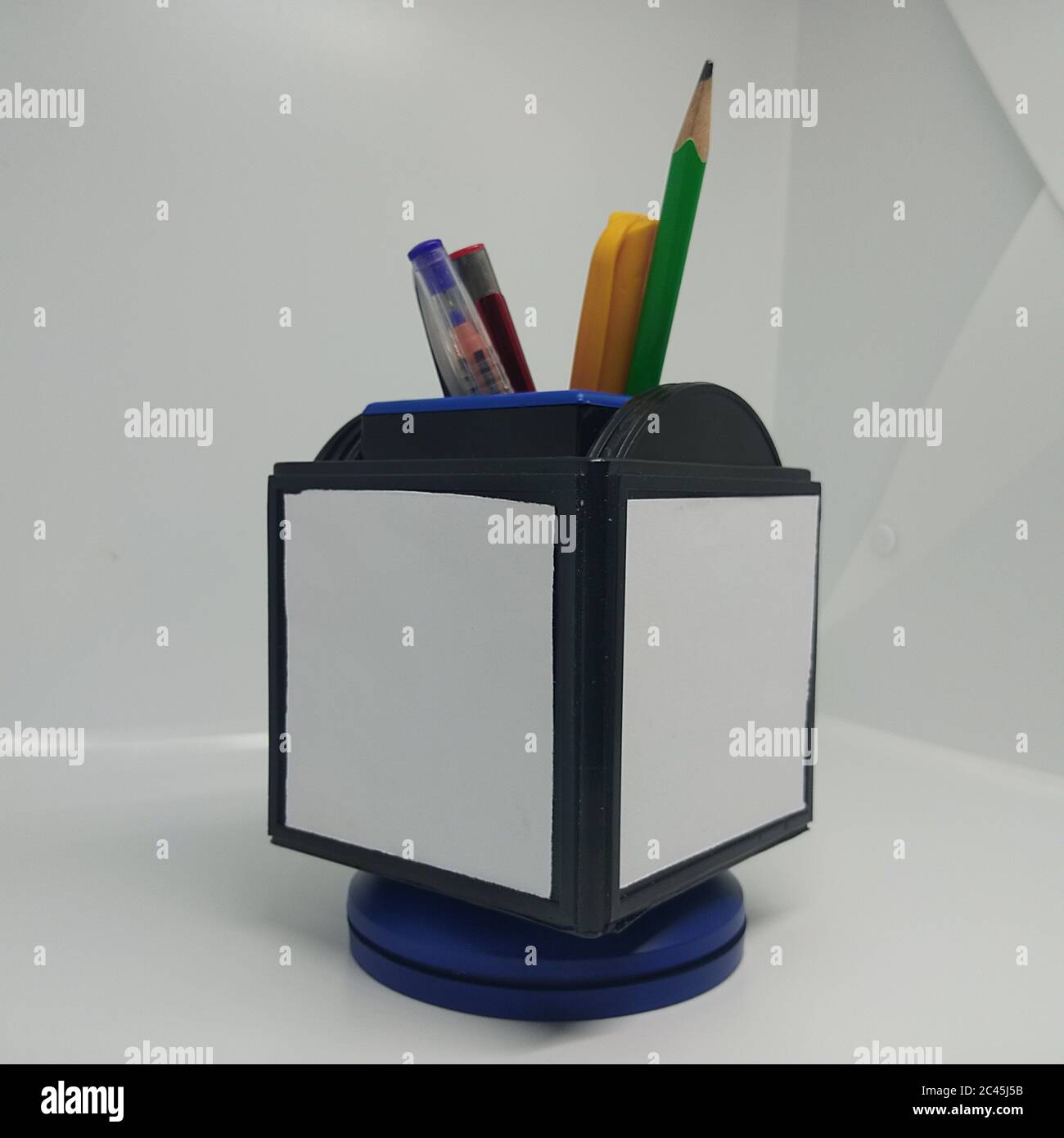 posizionare le penne multicolore in un supporto per penna bianco Foto Stock