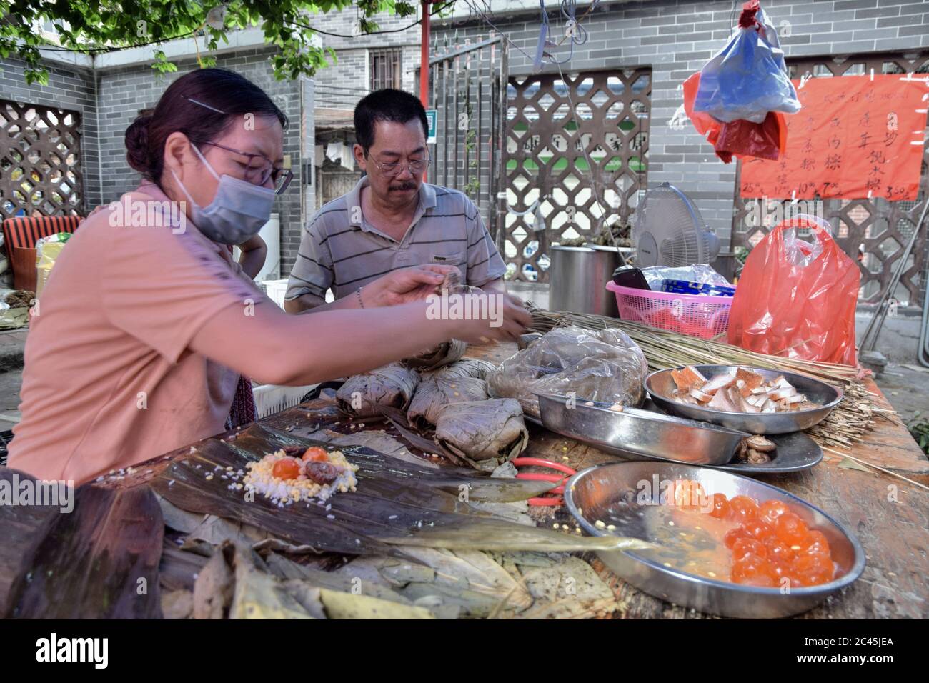 GUANGZHOU, CINA - CIRCA GIUGNO 2020: Fare zongzi, un piatto di riso cinese tradizionale che è fatto di riso glutinoso ripieno con diversi ripieni. Foto Stock