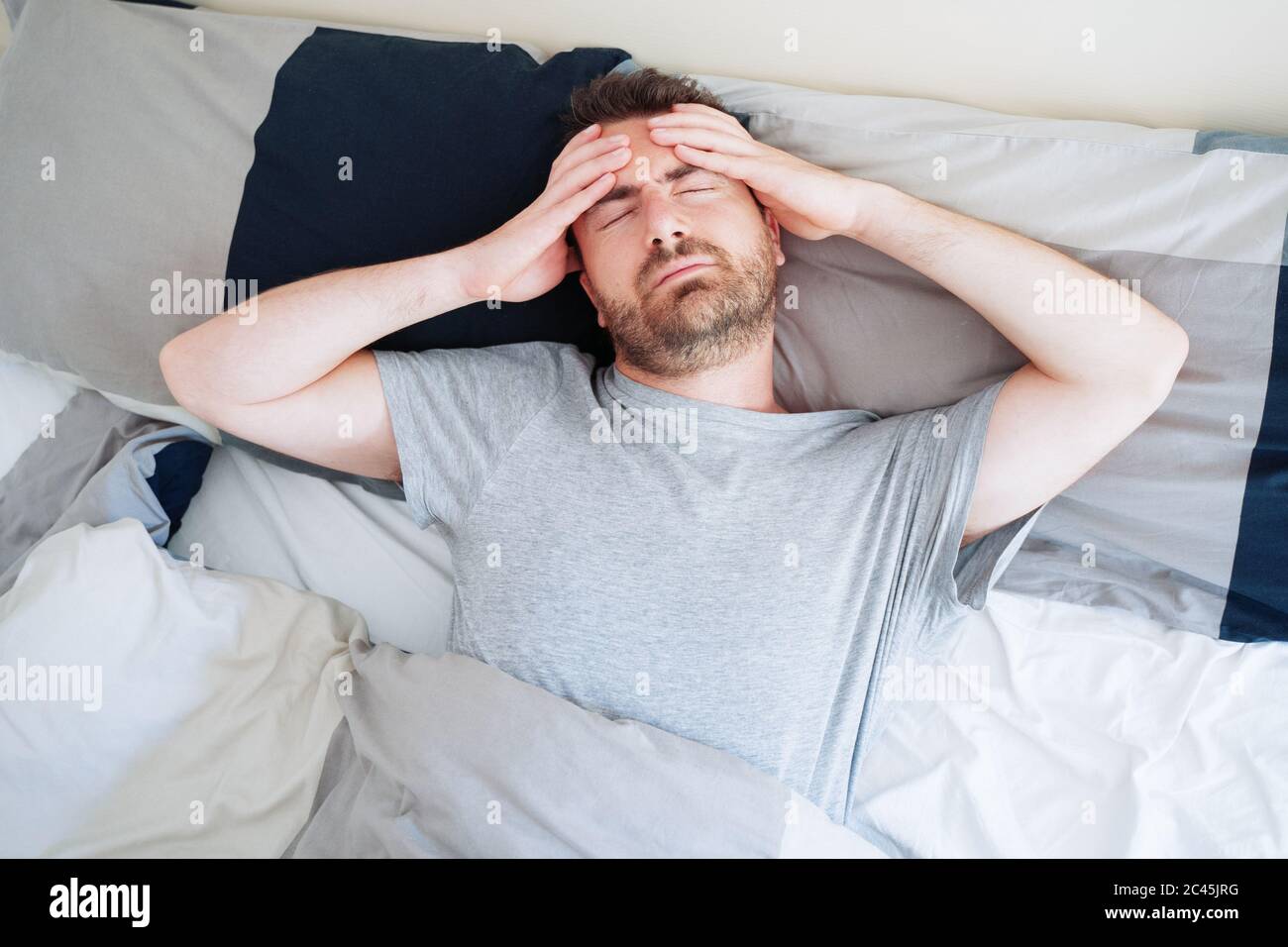 Uomo inquieto svegliarsi presto con mal di testa dopo notte travagliata  Foto stock - Alamy