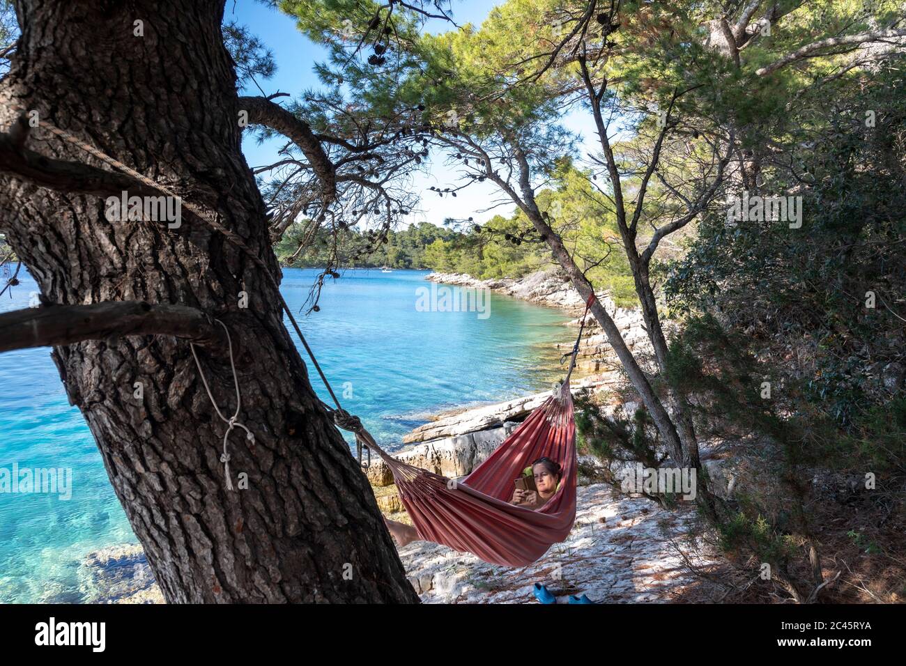 donna che legge in amaca sull'isola di mljet, croazia Foto Stock