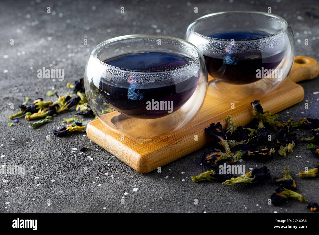 tè naturale blu floreale in bicchieri termoresistenti su sfondo scuro Foto Stock