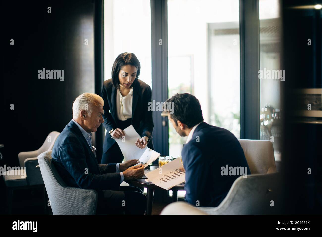 Imprenditrice e uomini che incontro in hotel Ristorante Foto Stock