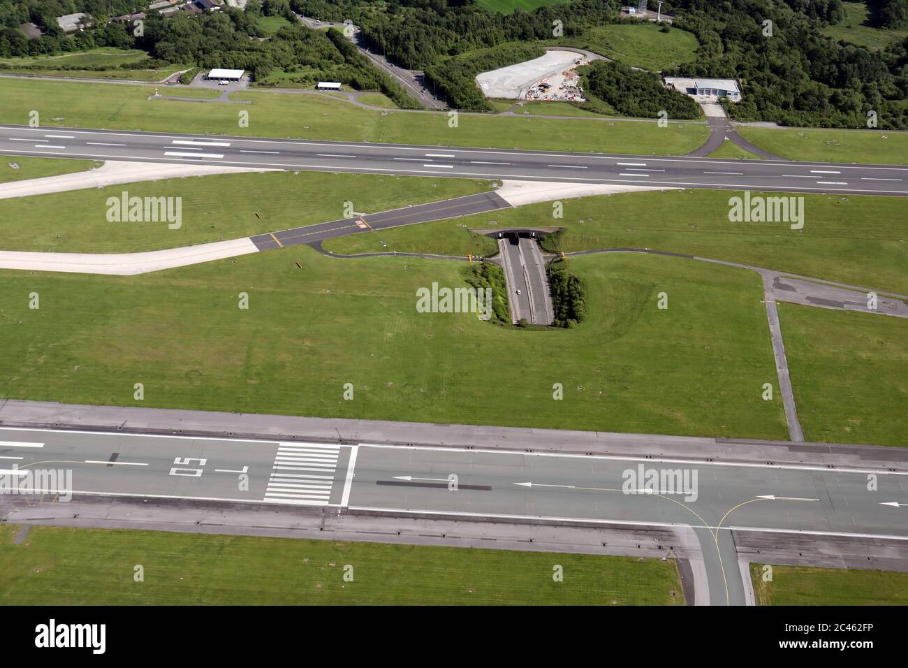 Vista aerea di una breve sezione della A538 Wilmslow Road tra le due piste dell'aeroporto internazionale di Manchester Foto Stock