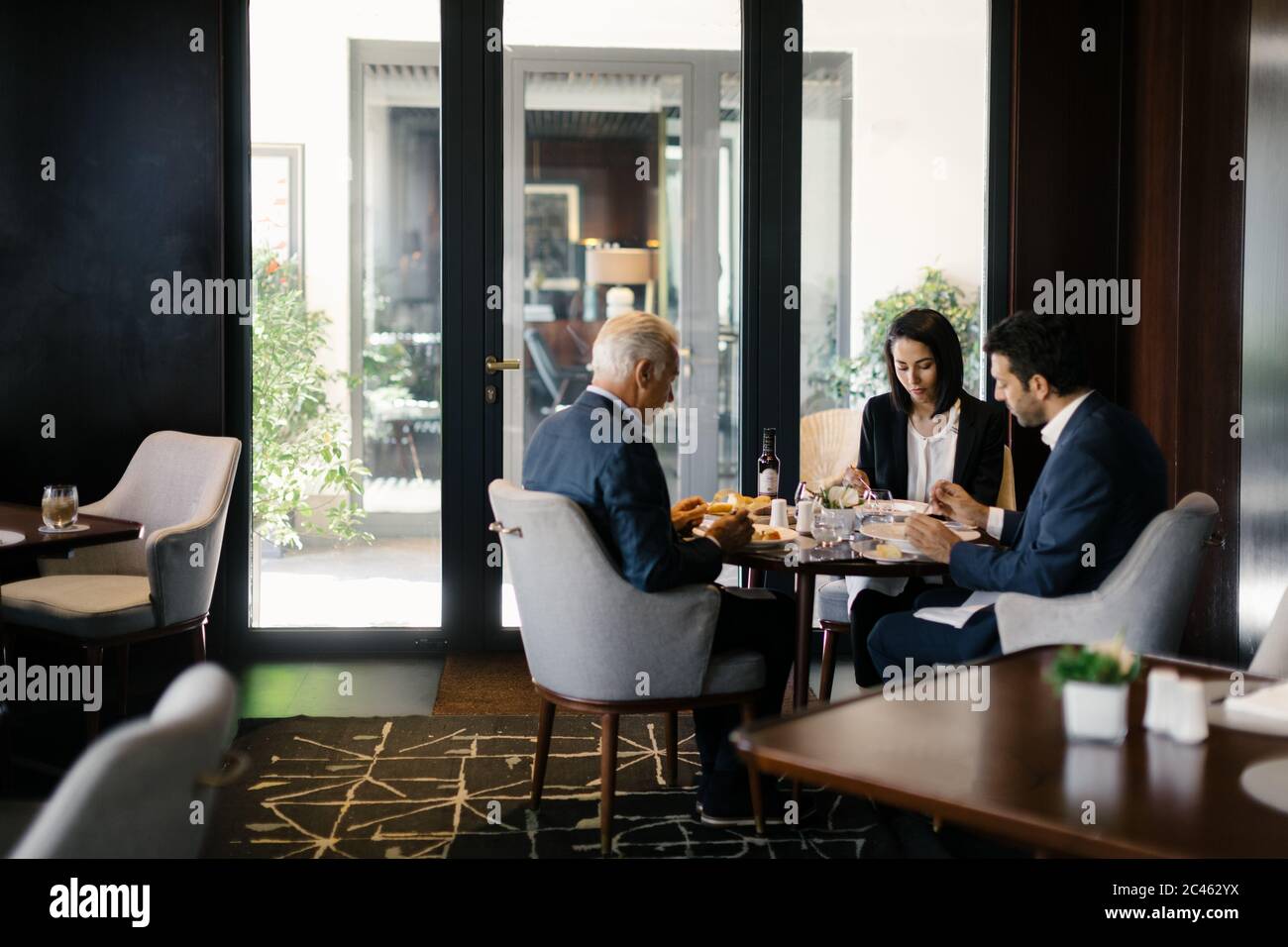 Due imprenditori e la donna con un pranzo di lavoro in hotel Ristorante Foto Stock