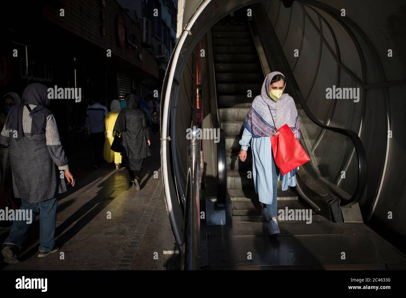 Teheran, Iran. 23 Giugno 2020. Una donna che indossa una maschera facciale prende una scala mobile a Teheran, Iran, 23 giugno 2020. L'Iran ha segnalato 2,531 nuovi casi COVID-19 nelle ultime 24 ore, portando il numero totale nel paese a 212,501 mercoledì, l'agenzia ufficiale di stampa IRNA ha riferito. Credit: Ahmad Halabisaz/Xinhua/Alamy Live News Foto Stock