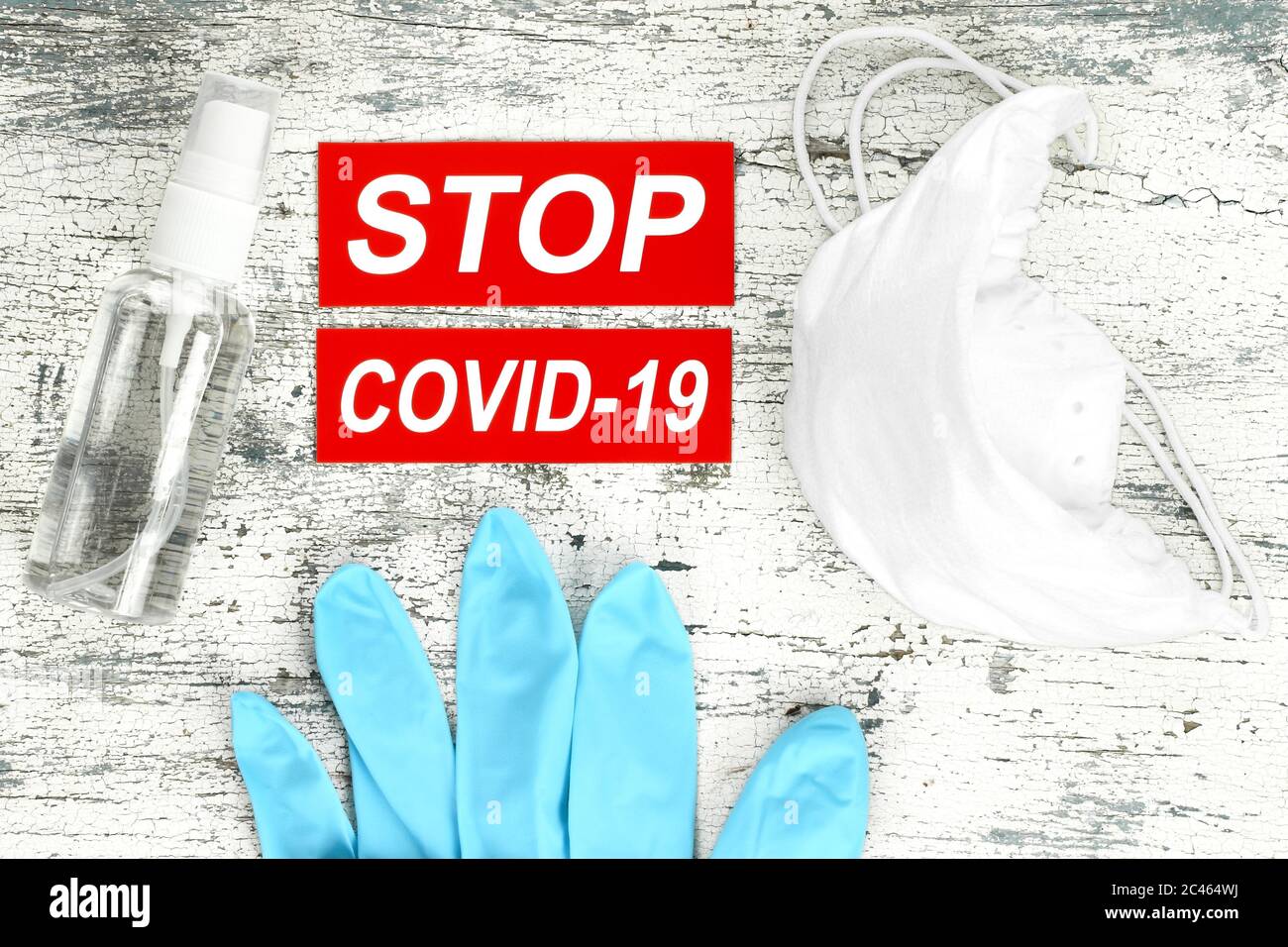 Virus di arresto Covid-19 concetto con guanti medici, spray antisettico e respiratore medico, su sfondo di legno Foto Stock
