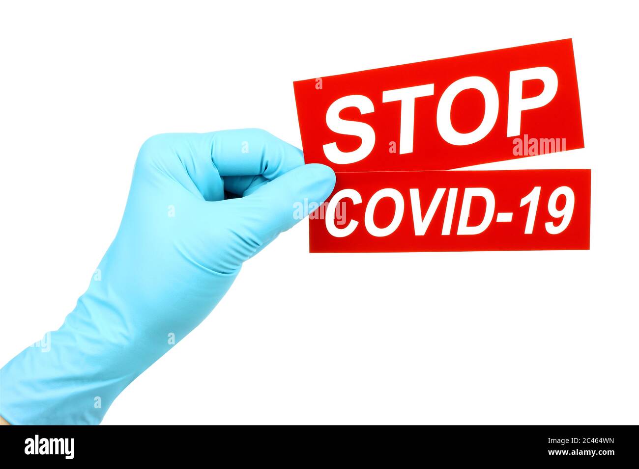 La mano della donna nei guanti medici tiene il segno rosso Stop Covid-19 su sfondo bianco Foto Stock