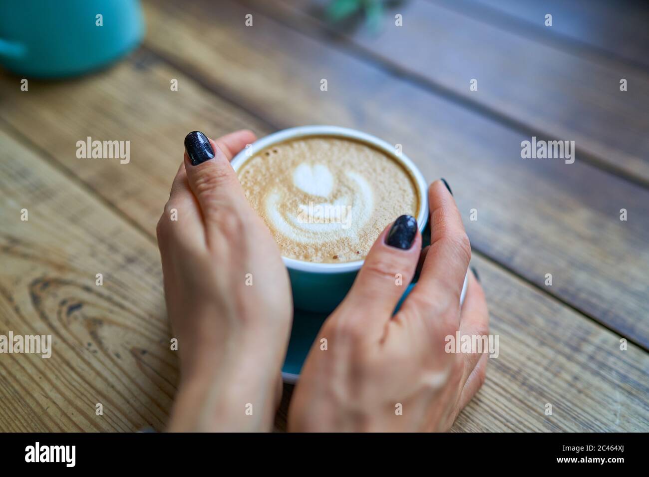 Una tazza di delizioso caffè forte in mani femminili. Bevande concettuali, stile di vita, lavoro, background Foto Stock
