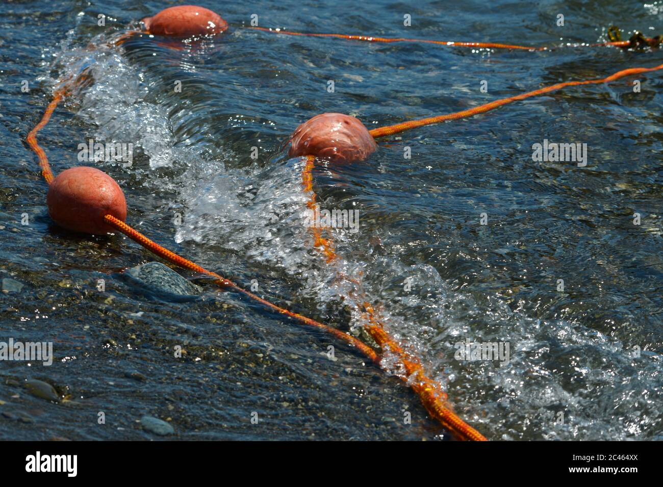 Galleggianti di sicurezza costieri lanciati dall'onda del mare a riva. Foto Stock