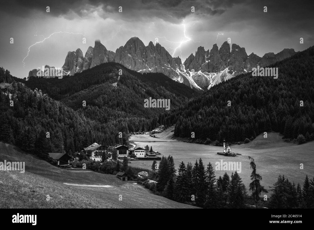 Immagine drammatica di maestose montagne e fulmini nel villaggio di San Magdalena nelle Dolomiti Foto Stock