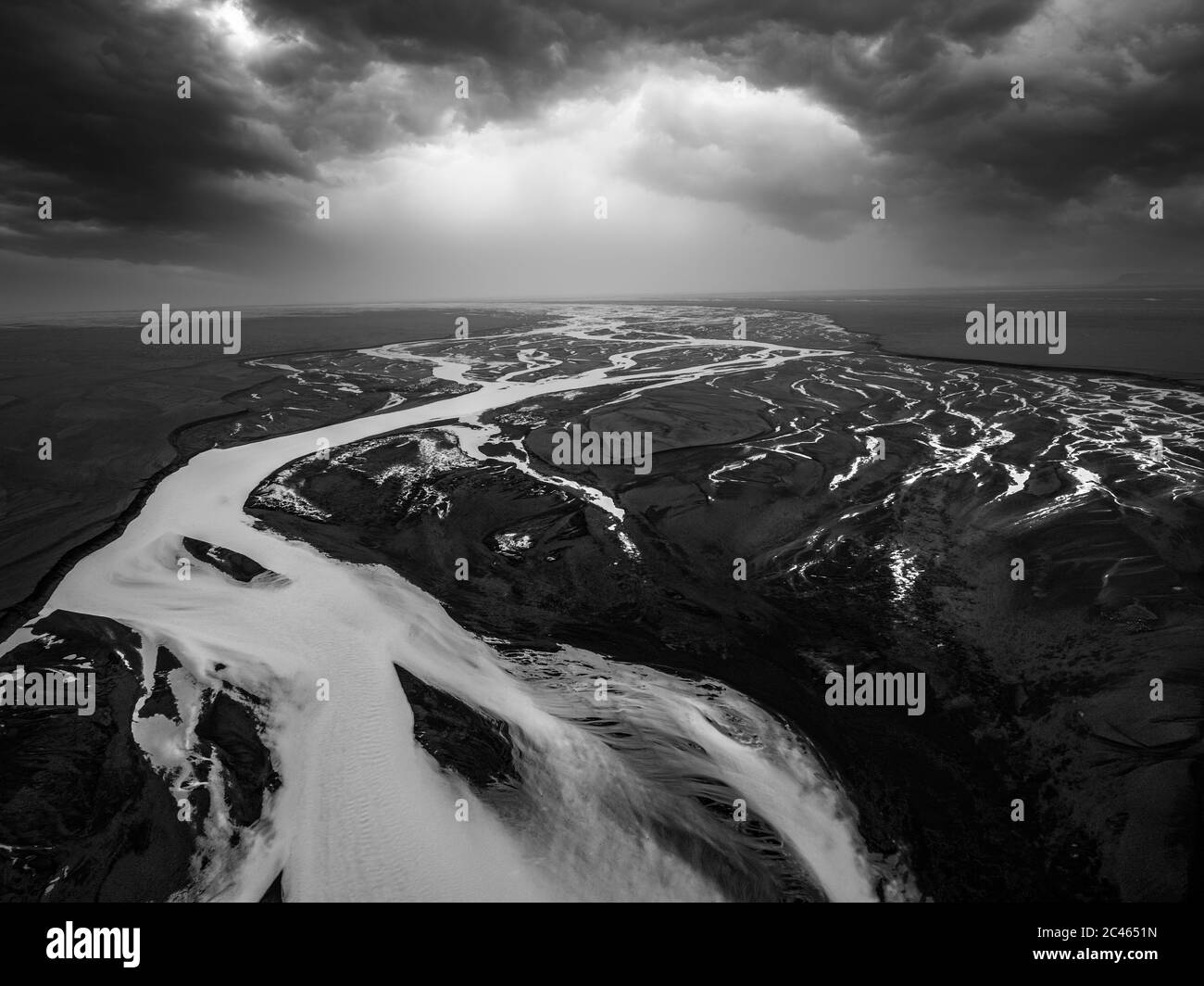 Immagine aerea in bianco e nero di modelli fluviali e nubi drammatiche in Islanda Foto Stock