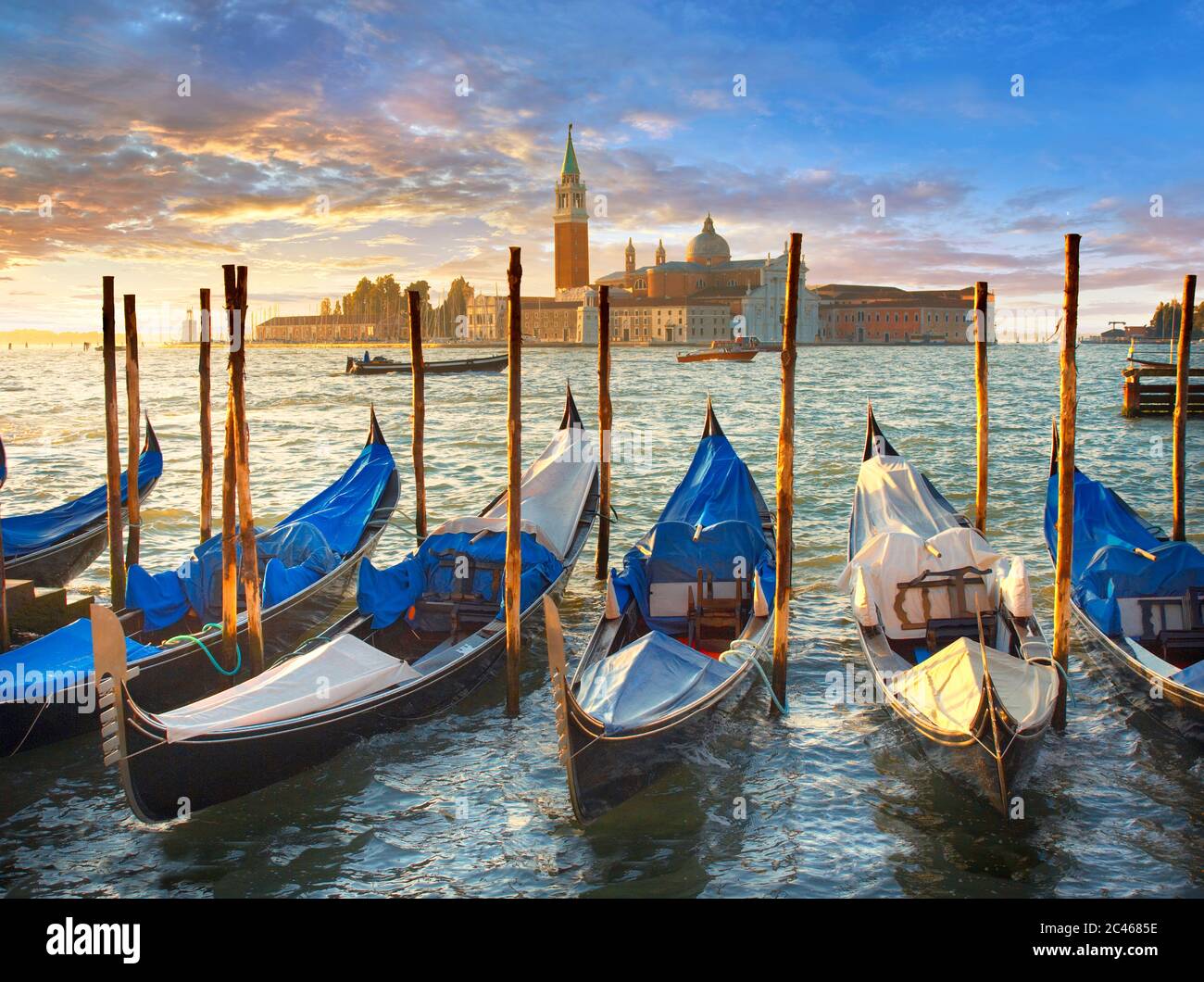 Vista al tramonto delle gondole in Piazza San Marco con alle spalle l'isola di San Giorgio maggiore , con il fronte della chiesa disegnato da Andrea Palladio e beg Foto Stock