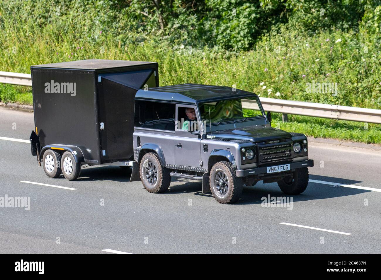 2007 immagine 4x4 modificato grigio nero fuoristrada Land Rover Defender 90 Hard Top; veicoli in movimento per il traffico veicolare, veicoli in movimento su strade del Regno Unito, motori, veicoli in moto con rimorchio sull'autostrada M6 Foto Stock