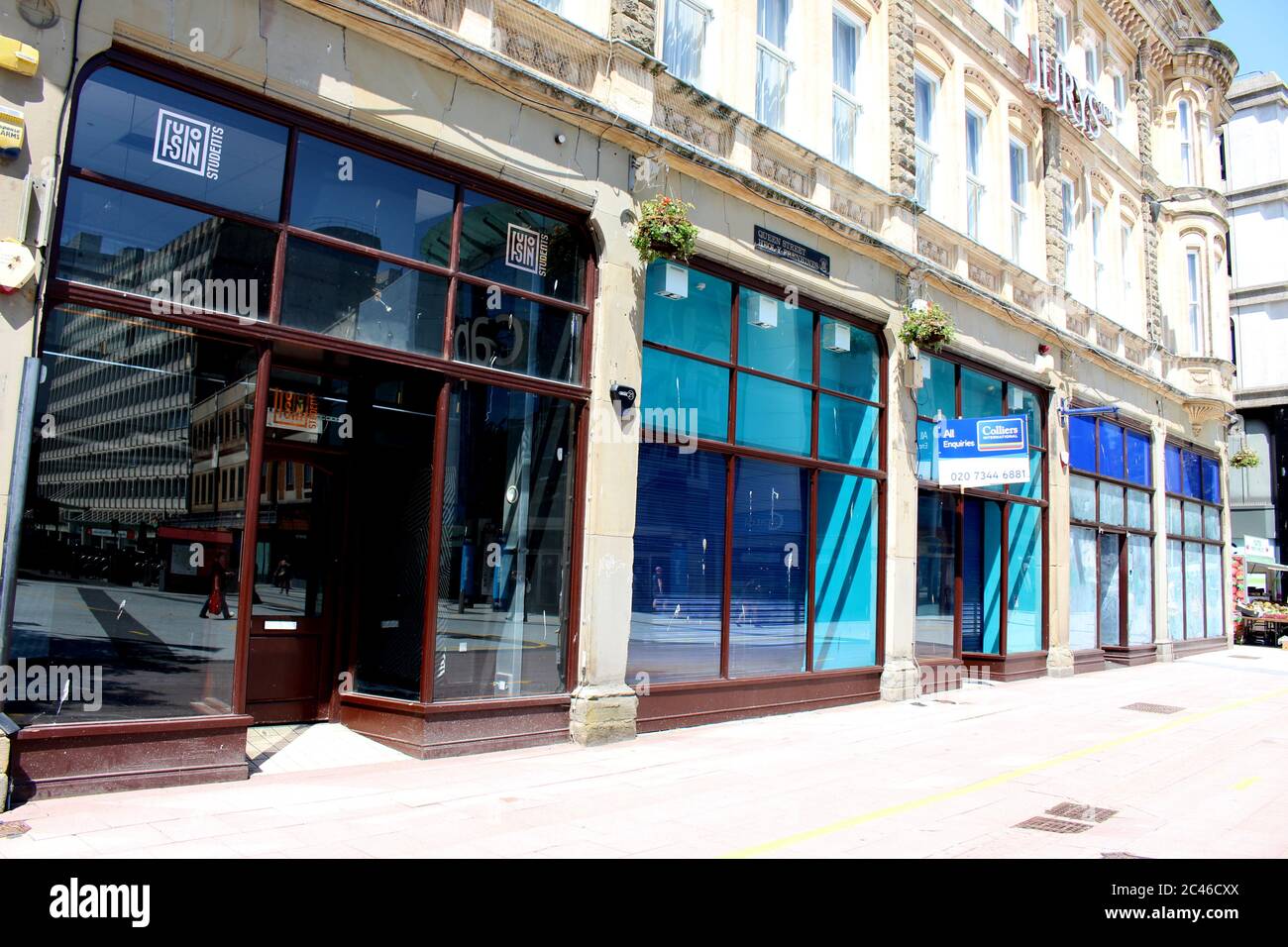 Una fotografia di negozi vuoti su Cardiff Queen Street. Recessione economica. Foto Stock