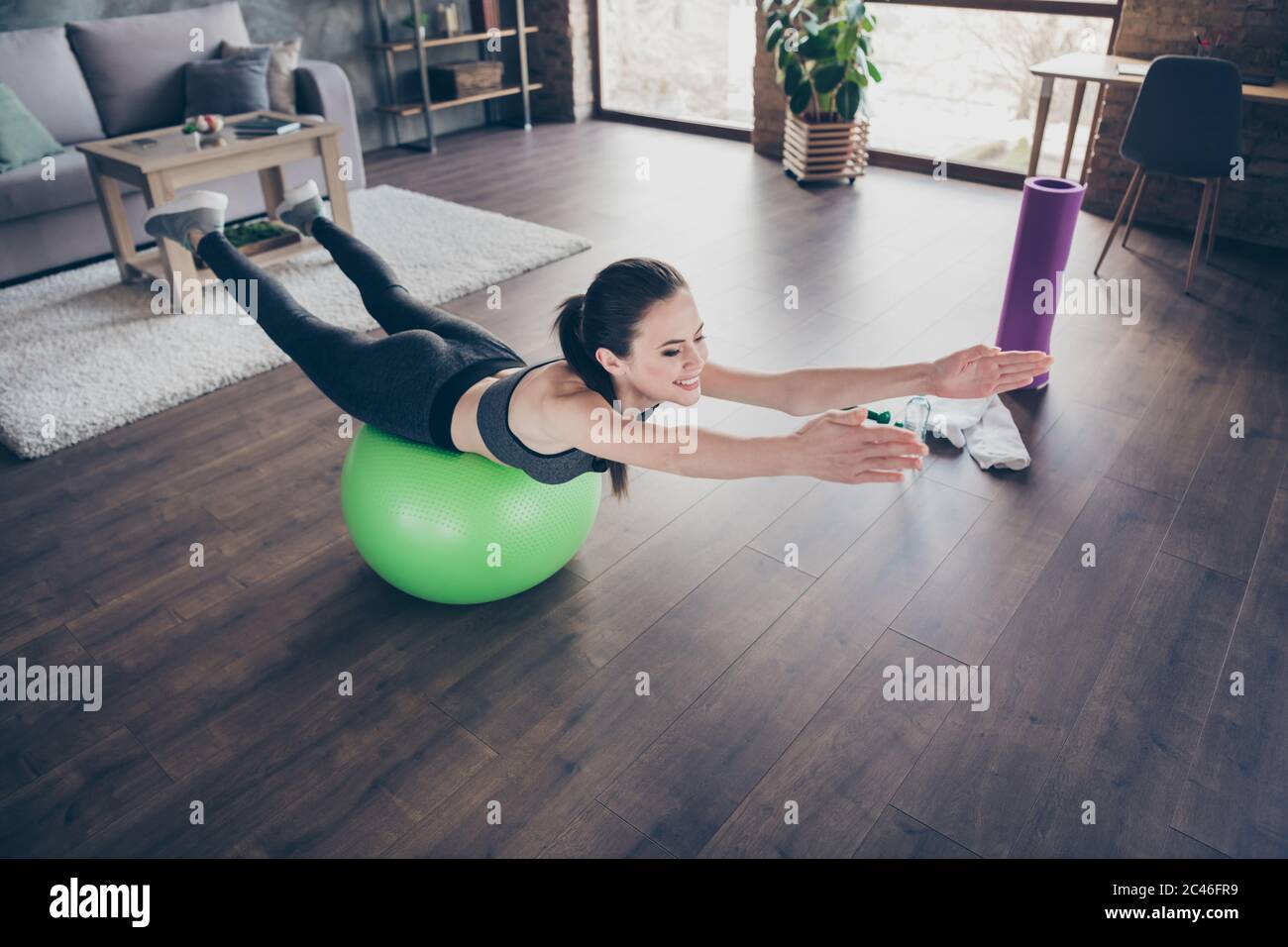 Foto profilo di bella donna hobby quarantena formazione casa pilates dinamica che si estende pratica giacendo su palla fit fare esercizi per tutti i muscoli Foto Stock