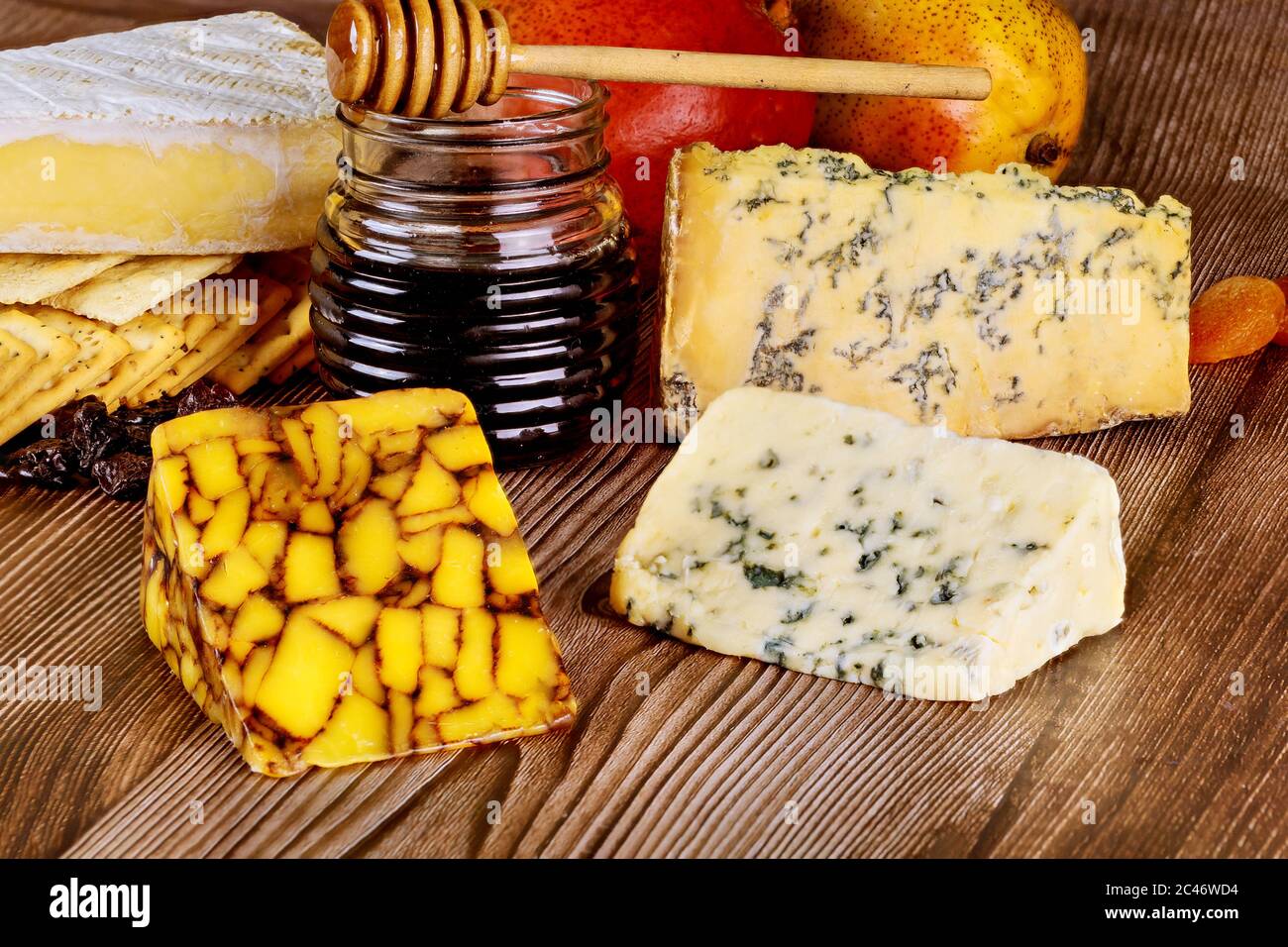 Miele e diversi tipi di formaggio su sfondo ligneo. Foto Stock