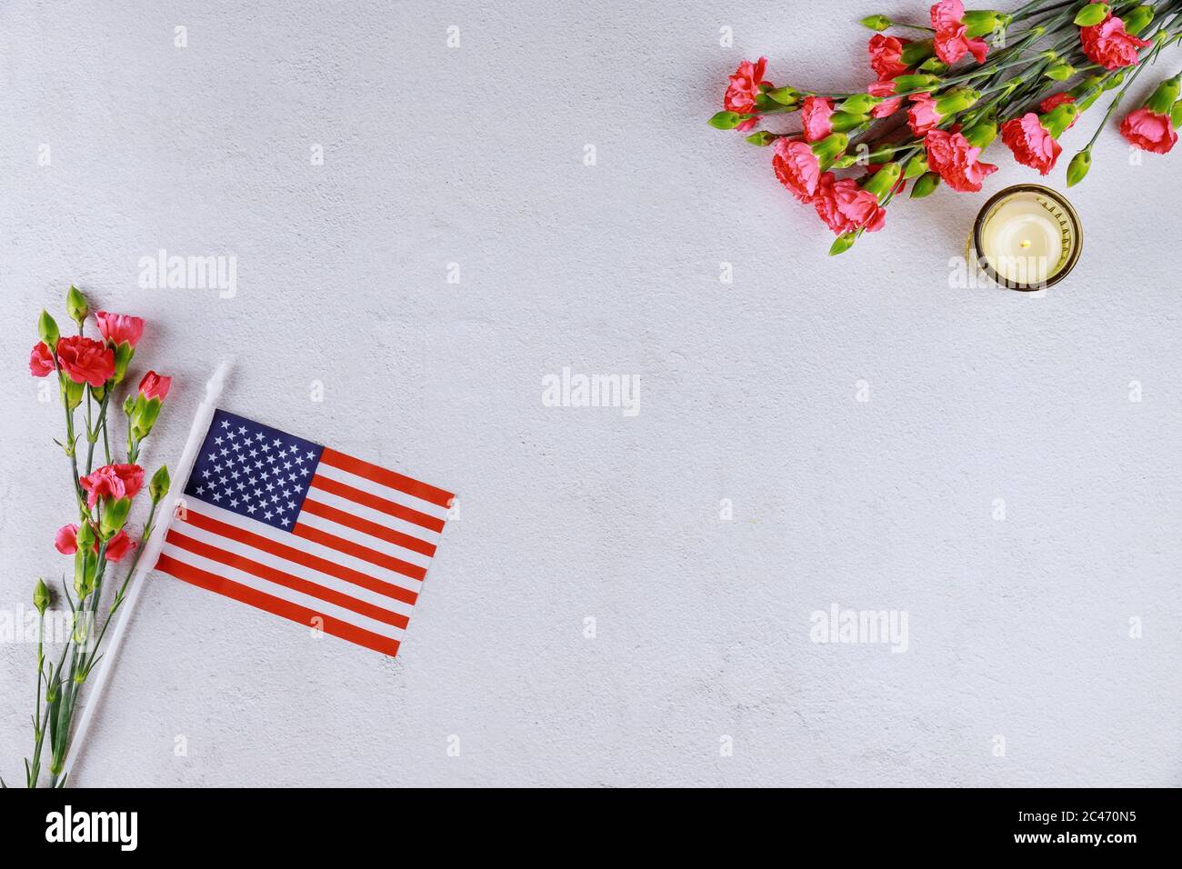 BANDIERA DEGLI STATI UNITI, fiori e candela su sfondo bianco. Giorno della memoria o dei veterani. Foto Stock