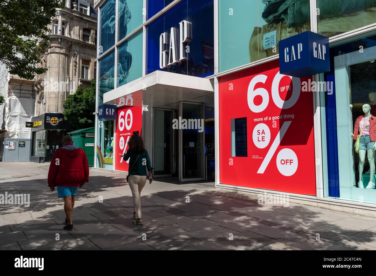 Il negozio della società di abbigliamento Gap a Londra Oxford Street con grandi cartelli di riduzione dei prezzi di vendita vicino all'ingresso. Foto Stock