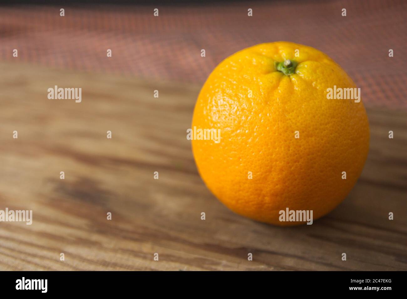 Primo piano di un arancio maturo su un tavolo di legno con sfondo scuro e con spazio per i testi (spazio copia) Foto Stock