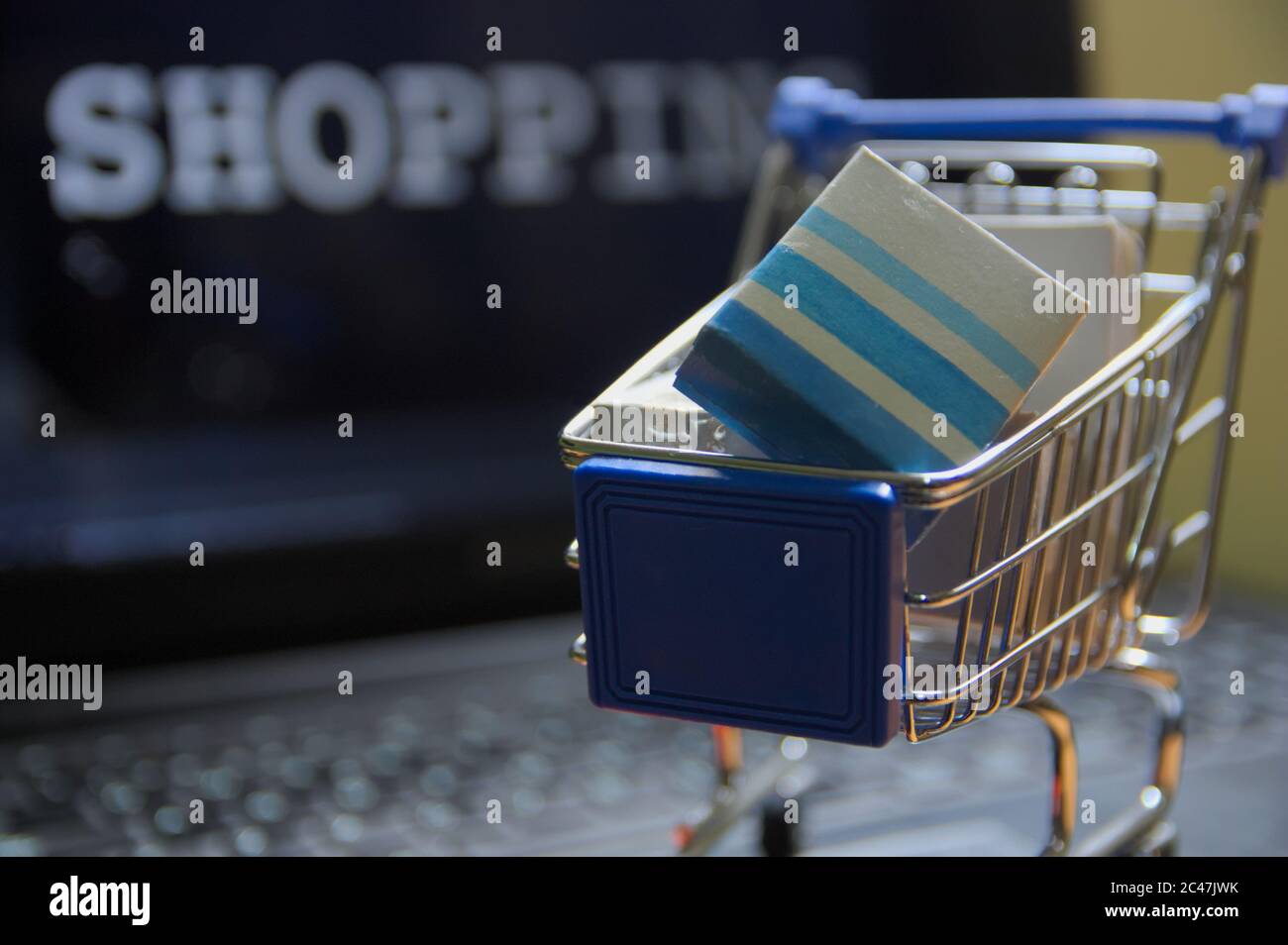 Immagine concettuale sugli acquisti tramite nuove tecnologie e online. Un carrello di shopping in miniatura in cui ci sono un sacco di scatole simbolizzando virtuale Foto Stock
