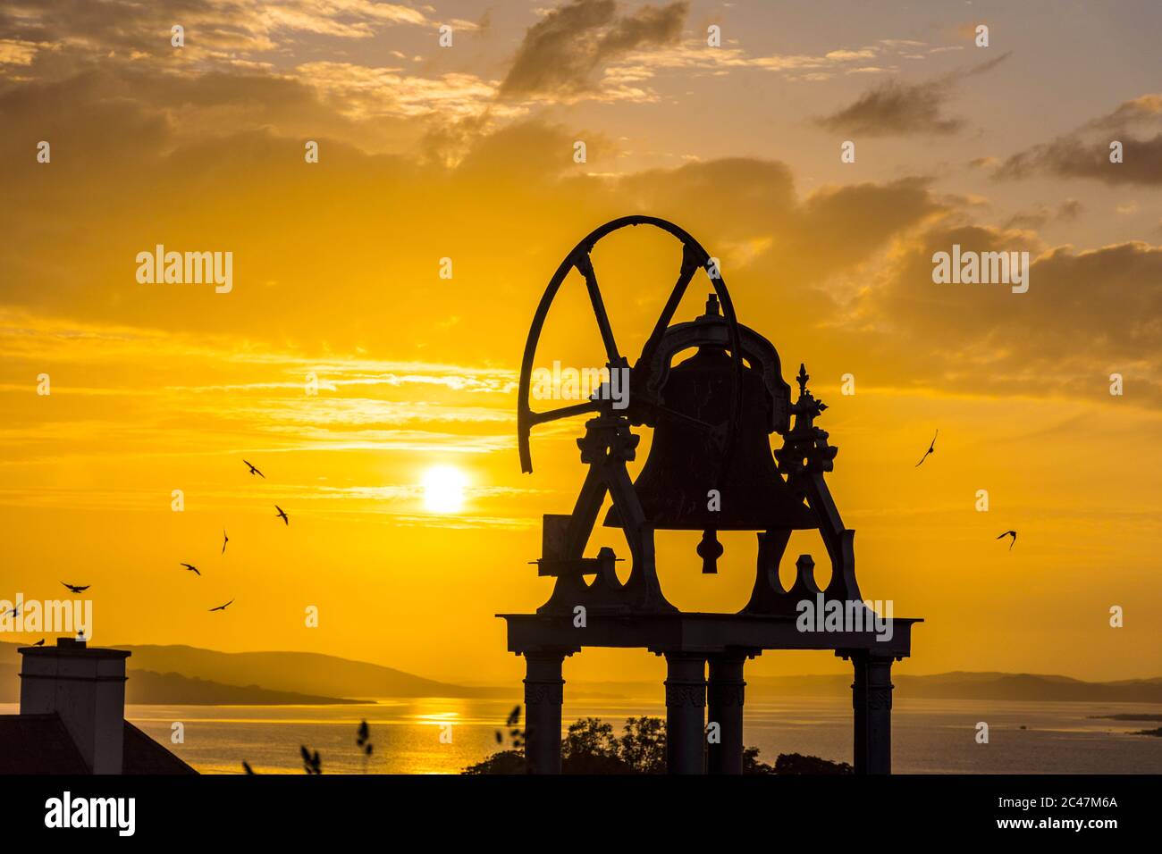 Ardara, Contea di Donegal, Irlanda 24 giugno 2020. Il sole tramonta sul villaggio costiero dell'Oceano Atlantico che si staglia sulla torre campanaria della chiesa. Foto Stock