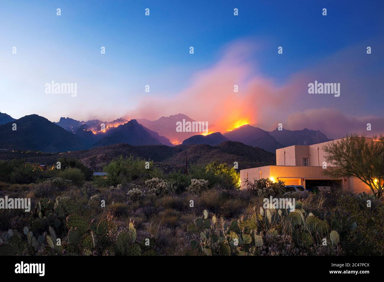 Bighorn Fire accroaching e minaccioso case ai piedi delle montagne di Santa Catalina vicino Sabino Canyon, Tucson, Arizona, Stati Uniti Foto Stock