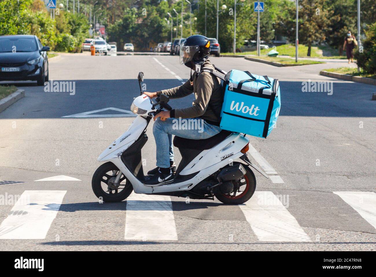 Almaty, Kazakhstan - 13 giugno 2020: Il corriere Wolt con scooter a motore sulla strada di Almaty Foto Stock
