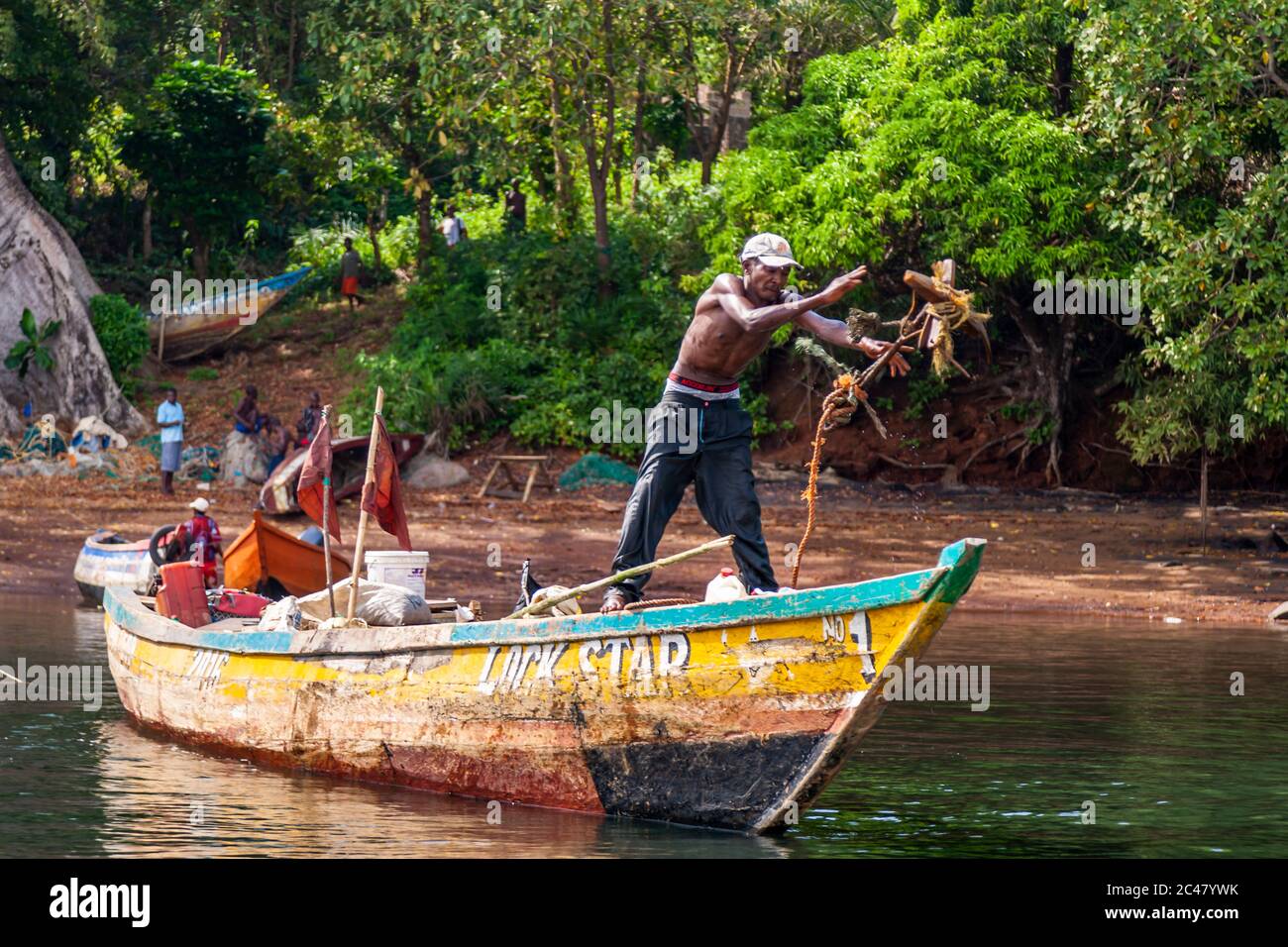 Un pescatore getta l'ancora da una barca chiamata la stella di bloccaggio su Banana Islane, Sierra Leone Foto Stock