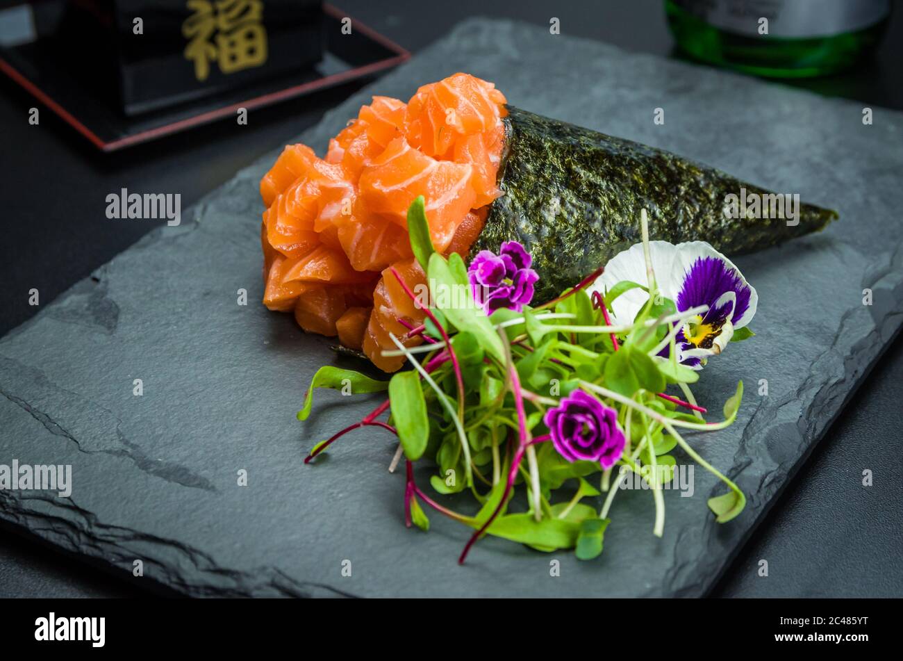 Sushi. Cucina tradizionale giapponese, salmone di alta qualità Temaki decorato in un ambiente elegante. Foto Stock